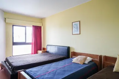 a hotel room with two beds and a window at Akisol Vilamoura Star II in Quarteira
