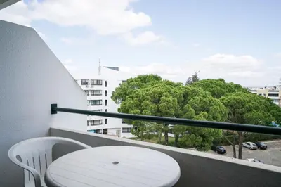 a white chair and a table on a balcony at Akisol Vilamoura Star II in Quarteira