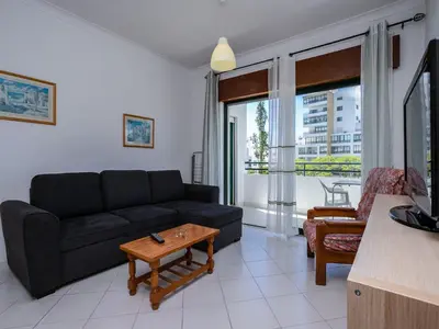a living room with a couch and a table at Akisol Quarteira Relax III in Quarteira