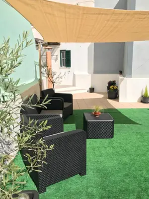 a patio with green grass and black furniture at MariaHouse in Faro