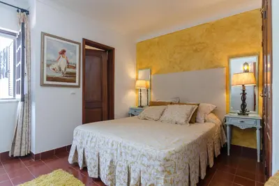 a bedroom with a bed and two lamps and a window at Villa Casa do Sul in Albufeira