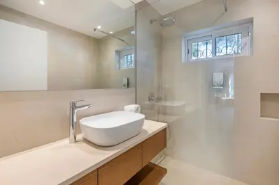 a white bathroom with a sink and a shower at Vilar do Golf in Quinta do Lago