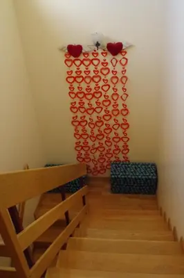 a staircase with a wall of red hearts on the wall at BellaVita City Faro in Faro