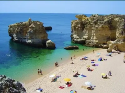 a group of people on a beach with umbrellas at Casa Azul in Albufeira