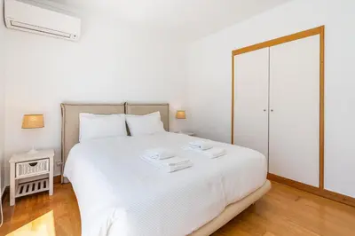 a bedroom with a white bed with two trays on it at Marina Vilamoura Triplex in Vilamoura