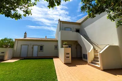 a large white house with a grass yard at Vila do Castelo in Albufeira