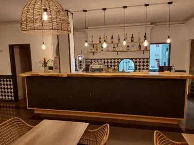 a bar in a restaurant with a table and chairs at Vila do Castelo in Albufeira
