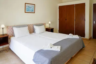 a bedroom with a large bed with white shoes on it at Cheerfulway Ouravista Apartamentos in Albufeira