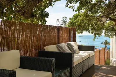 a patio with chairs and a fence and the ocean at 3HB Golden Beach in Albufeira