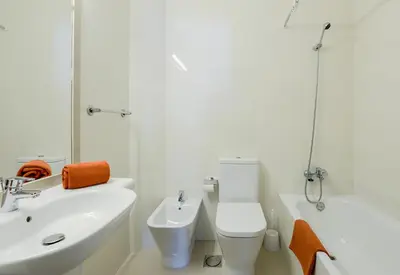 a white bathroom with a sink and a toilet at 3HB Golden Beach in Albufeira