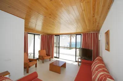 a living room with a couch and a tv at Apartamentos Tio Papel in Albufeira