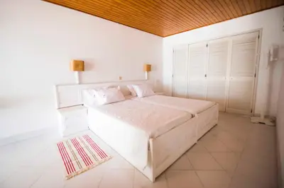 a bedroom with a large white bed in a room at Apartamentos Tio Papel in Albufeira