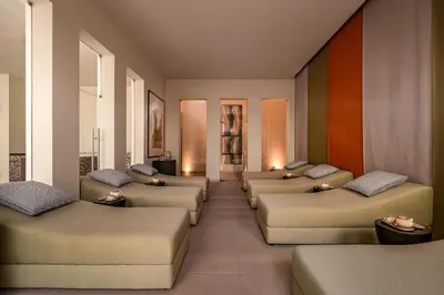 a hotel room with two chairs and a tv at Kimpton Atlantico Algarve by IHG in Albufeira