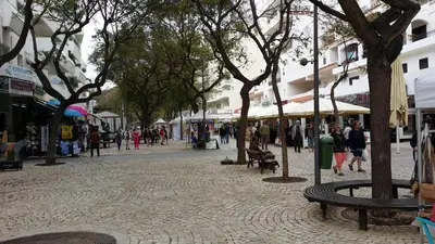 a group of people walking around a street with trees at Studio near the beach in Albufeira
