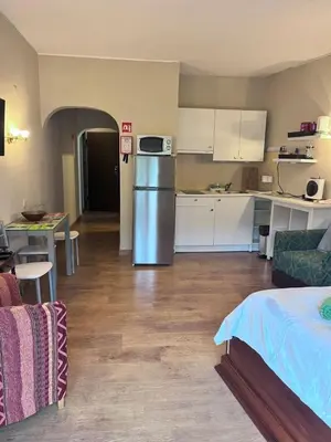 a kitchen and living room with a refrigerator and a table at Studio near the beach in Albufeira