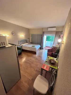 a small room with a bed and a desk and a kitchen at Studio near the beach in Albufeira