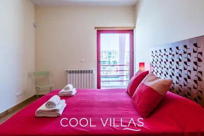 a bedroom with a large red bed with towels on it at Villa AcquaMarina - 5 bedroom, water front villa in Albufeira