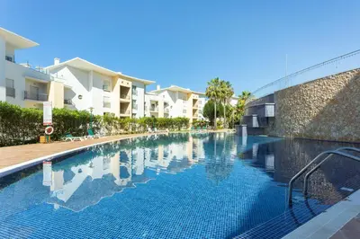 a swimming pool in front of some apartment buildings at Encosta Da Orada by Garvetur in Albufeira
