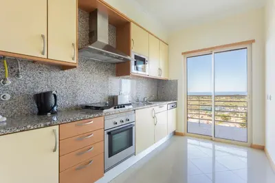 a kitchen with a view of the ocean at Encosta Da Orada by Garvetur in Albufeira