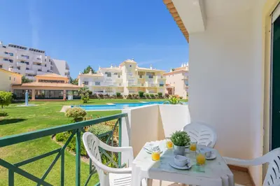 a table and chairs on the balcony of a house at Jardins Santa Eulalia by Garvetur in Albufeira