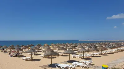 a bunch of umbrellas and chairs on a beach at Quinta Do Romão in Vilamoura