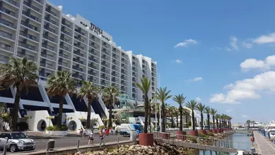 a large hotel on the beach with palm trees at Quinta Do Romão in Vilamoura