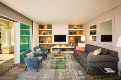 a living room with a couch and chairs and a tv at Vila Balaia - Luxury Boutique Villas in Albufeira