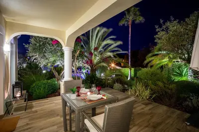 a table and chairs on a patio at night at Vila Balaia - Luxury Boutique Villas in Albufeira