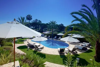 a swimming pool with umbrellas and chairs and a pool at Vila Balaia - Luxury Boutique Villas in Albufeira