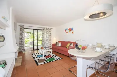 a living room with a red couch and a table at Apartamento Solar in Quarteira