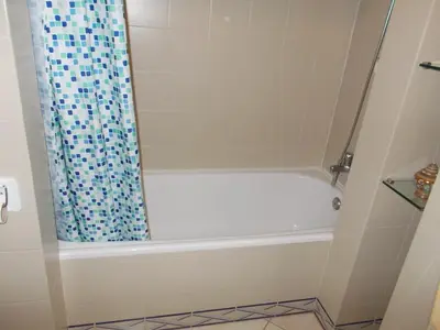 a bathroom with a bath tub with a shower curtain at Bellavista Apartments in Albufeira