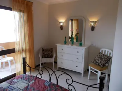 a bedroom with a bed and a dresser and a mirror at Bellavista Apartments in Albufeira