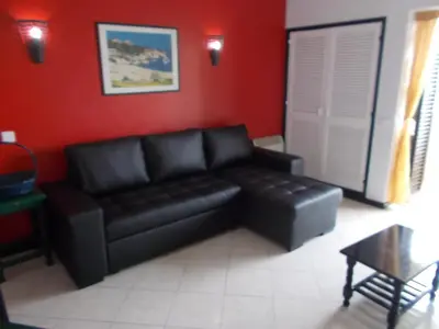 a black leather couch in a red living room at Bellavista Apartments in Albufeira