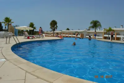 a large swimming pool with people in the water at Vila Branca in Mosqueira