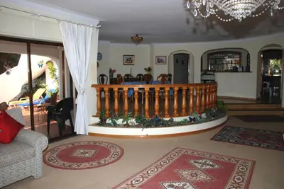 a living room with a chandelier and a staircase at Genies Villa Boutique Algarve in Almancil