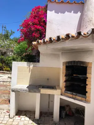 an outdoor kitchen with a fireplace in a yard at Genies Villa Boutique Algarve in Almancil