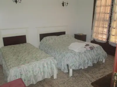 a bedroom with two beds and two windows at Vivendas Costa in Barros da Fonte Santa