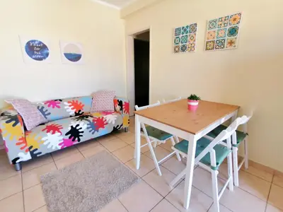 a living room with a table and a couch at Apartamento Penha T3 in Faro