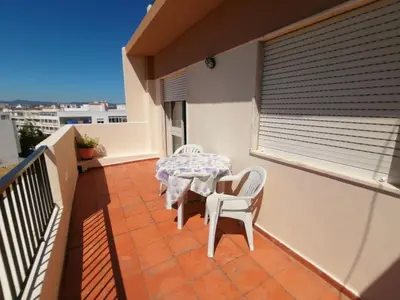 a patio with a table and chairs on a balcony at Apartamento Penha T3 in Faro