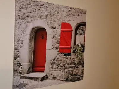 a red door and two windows in a stone building at Apartamento Penha T3 in Faro