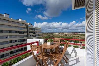 a balcony with a wooden table and two chairs at Marina Vilamoura Relax in Vilamoura