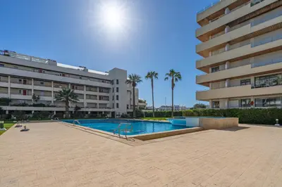 a swimming pool in front of a building at Marina Vilamoura Relax in Vilamoura