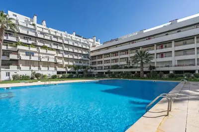 a swimming pool in front of a building at Marina Vilamoura Relax in Vilamoura