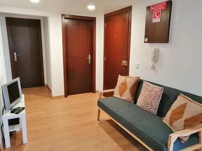 a living room with a green couch and a television at Apartamento Penha in Faro