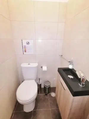 a bathroom with a white toilet and a sink at Apartamento Penha in Faro