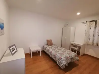 a bedroom with a bed and a table and a chair at Apartamento Penha in Faro