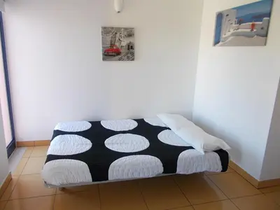 a bed in a room with a black and white blanket at T1 e T2 Marina Albufeira apartments in Albufeira