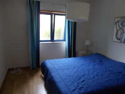 a bedroom with a blue bed and a window at T1 e T2 Marina Albufeira apartments in Albufeira