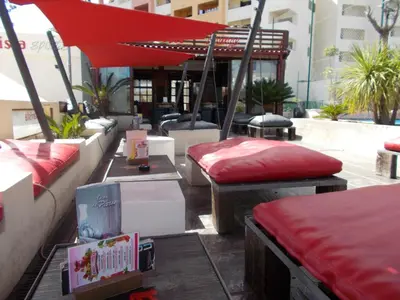 a patio with two beds and a red umbrella at T1 e T2 Marina Albufeira apartments in Albufeira