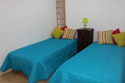two beds in a room with blue sheets at 5 Minutes Walk from the Beach in Albufeira